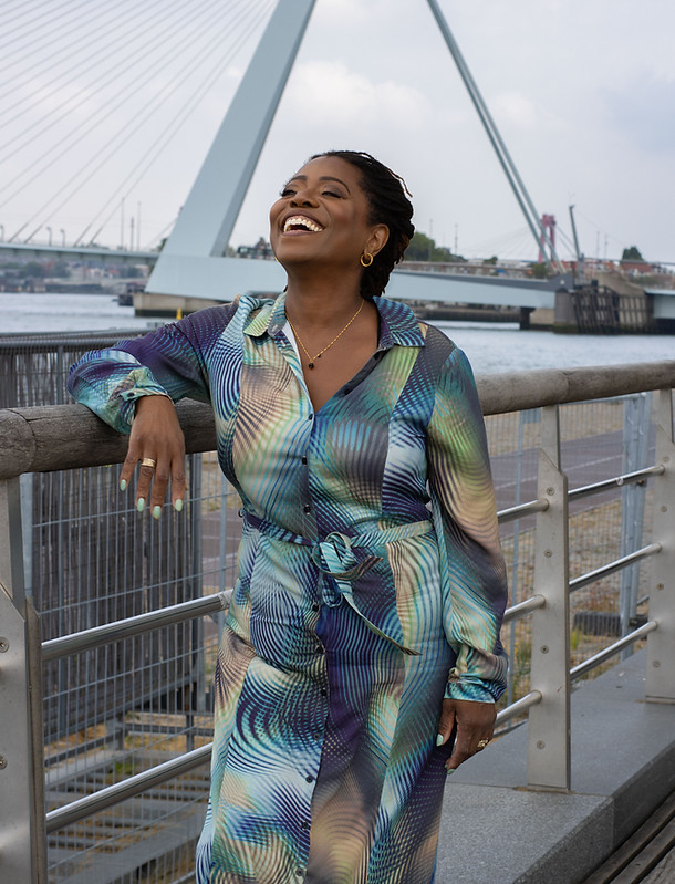 Niza Roqué lachend aan het water bij de Erasmusbrug in Rotterdam